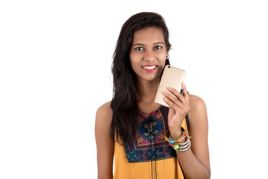 Portrait of a happy young girl using mobile phone isolated over white background