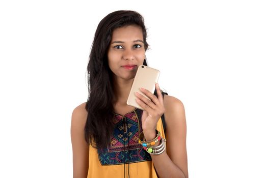 Portrait of a happy young girl using mobile phone isolated over white background