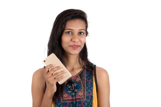 Portrait of a happy young girl using mobile phone isolated over white background