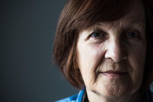 Close-up portrait of senior woman's wrinkled face.