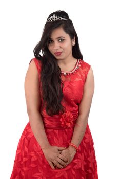 Young girl in red dress posing on white background