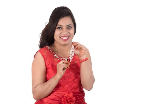 Young girl in red dress posing on white background