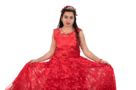 Young girl in red dress posing on white background