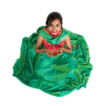 Portrait of a Indian Traditional Girl holding Diya, Girl Celebrating Diwali or Deepavali with holding oil lamp during festival of light on white background