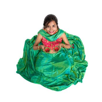 Portrait of a Indian Traditional Girl holding Diya, Girl Celebrating Diwali or Deepavali with holding oil lamp during festival of light on white background