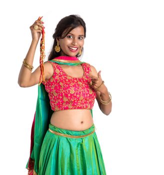 Beautiful girl showing Rakhi on occasion of Raksha bandhan on a white background. Sister tie Rakhi as symbol of intense love for her brother.