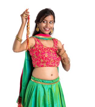 Beautiful girl showing Rakhi on occasion of Raksha bandhan on a white background. Sister tie Rakhi as symbol of intense love for her brother.