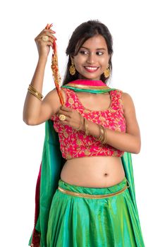 Beautiful girl showing Rakhi on occasion of Raksha bandhan on a white background. Sister tie Rakhi as symbol of intense love for her brother.