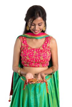 Beautiful girl showing Rakhi on occasion of Raksha bandhan on a white background. Sister tie Rakhi as symbol of intense love for her brother.