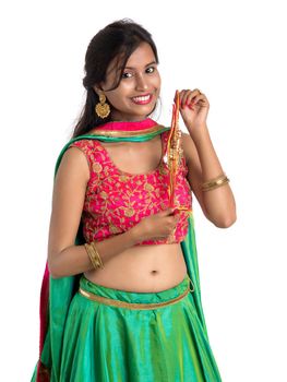 Beautiful girl showing Rakhi on occasion of Raksha bandhan on a white background. Sister tie Rakhi as symbol of intense love for her brother.