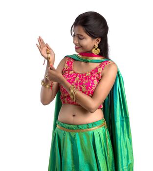 Beautiful girl showing Rakhi on occasion of Raksha bandhan on a white background. Sister tie Rakhi as symbol of intense love for her brother.