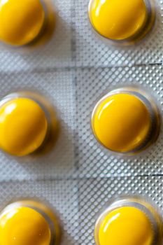 Yellow tablets in blister pack on black background