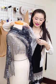 Asian American fashion designer dressing a mannequin