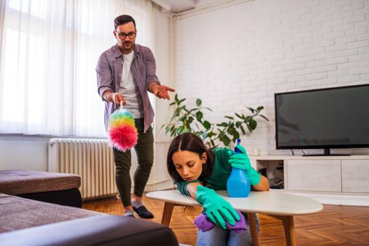 Lazy woman is refusing to clean the apartment. Man is angry.