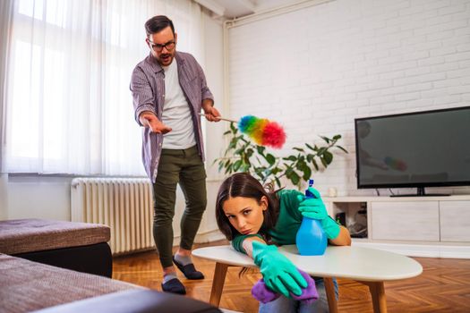 Lazy woman is refusing to clean the apartment. Man is angry.