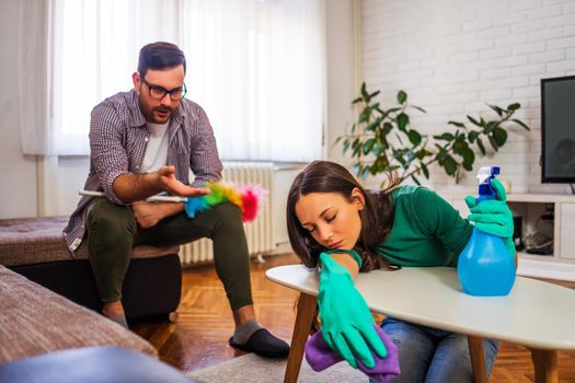 Lazy woman is refusing to clean the apartment. Man is angry.