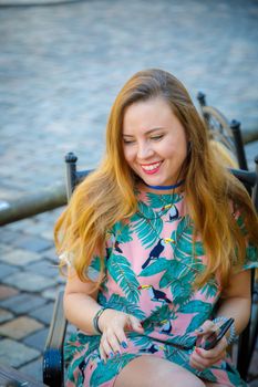 A young beautiful girl walks around the city on excursions. Cheerful, happy laugh.