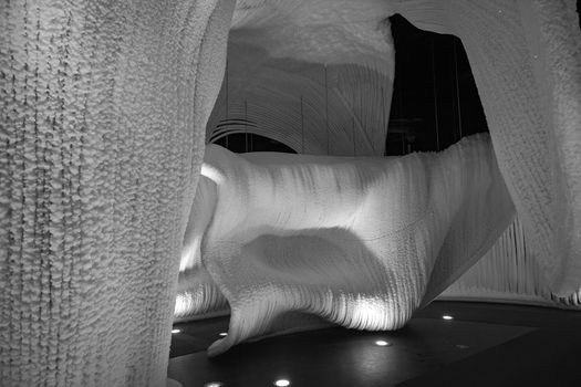 A fabulous artificial ice cave, the walls are covered with snow and illuminated. Frozen ice and cold inside