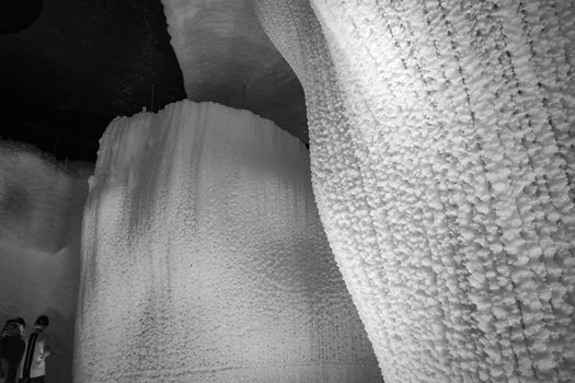 A fabulous artificial ice cave, the walls are covered with snow and illuminated. Frozen ice and cold inside