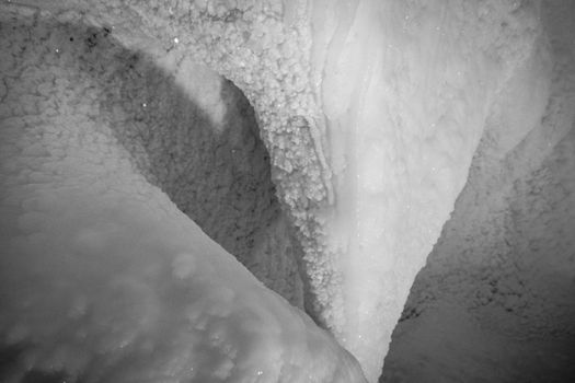 A fabulous artificial ice cave, the walls are covered with snow and illuminated. Frozen ice and cold inside