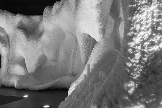 A fabulous artificial ice cave, the walls are covered with snow and illuminated. Frozen ice and cold inside