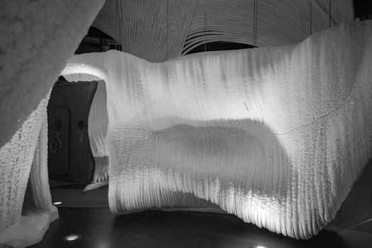 A fabulous artificial ice cave, the walls are covered with snow and illuminated. Frozen ice and cold inside