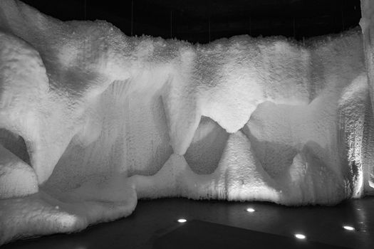 A fabulous artificial ice cave, the walls are covered with snow and illuminated. Frozen ice and cold inside