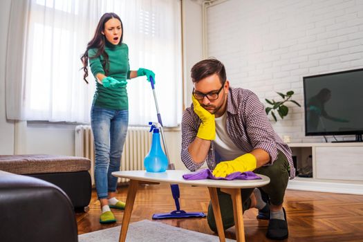 Man is tired of cleaning the apartment. Woman is angry.