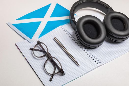 Learning foreign languages in Scotland with audio recordings and headphones. Notepad, glasses, pen.
