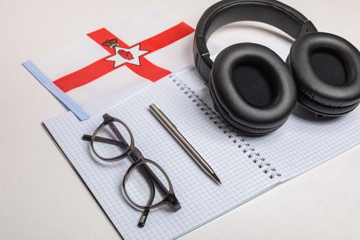 Learning foreign languages in Ireland with audio recordings and headphones. Notepad, glasses, pen.
