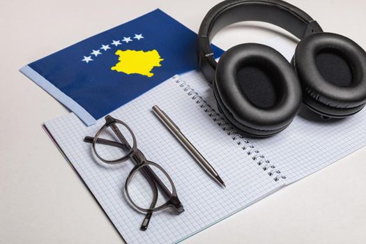 Learning foreign languages in Kosovo with audio recordings and headphones. Notepad, glasses, pen.