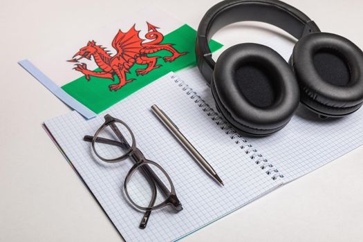 Learning foreign languages in Wales with audio recordings and headphones. Notepad, glasses, pen.