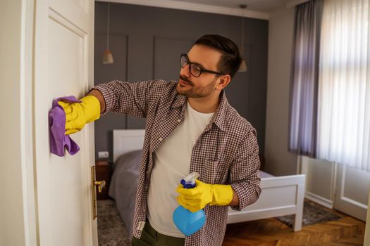 Young man is obsessively cleaning the apartment.