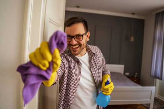 Young man is obsessively cleaning the apartment.