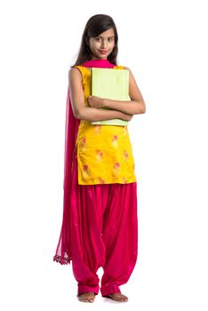 Pretty young girl holding book and posing on white background