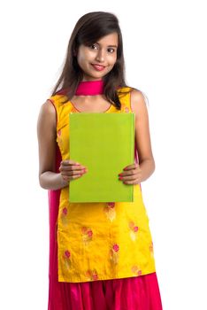 Pretty young girl holding book and posing on white background