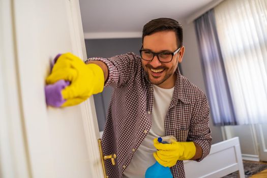 Young man is obsessively cleaning the apartment.