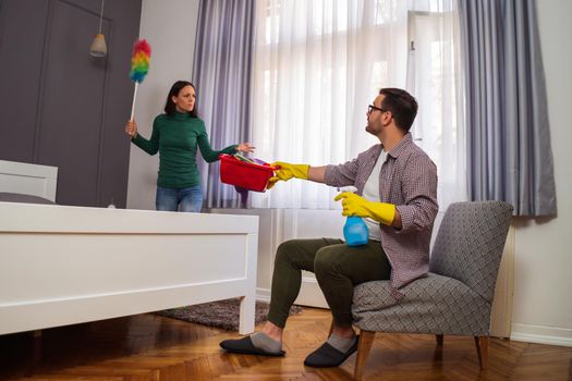 Woman is angry because her husband is lazy and avoids cleaning apartment.