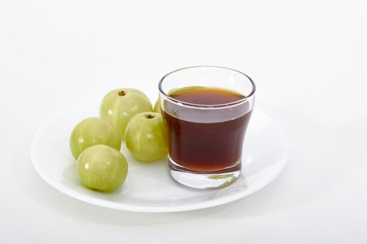 Fermented Gooseberry tonic and gooseberries on a white background