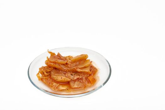 Kimchee on a glass plate on a white background