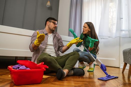 Man is lazy. His wife is telling him to continue cleaning their apartment.