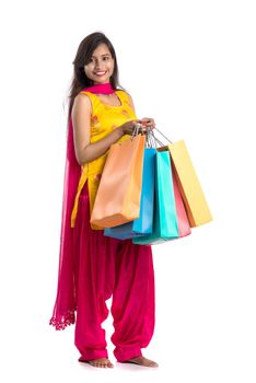 Beautiful Indian young girl holding and posing with shopping bags on a white background