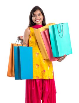 Beautiful Indian young girl holding and posing with shopping bags on a white background