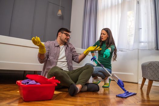 Man is lazy. His wife is telling him to continue cleaning their apartment.