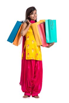 Beautiful Indian young girl holding and posing with shopping bags on a white background