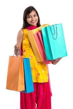 Beautiful Indian young girl holding and posing with shopping bags on a white background