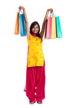 Beautiful Indian young girl holding and posing with shopping bags on a white background