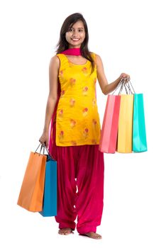 Beautiful Indian young girl holding and posing with shopping bags on a white background