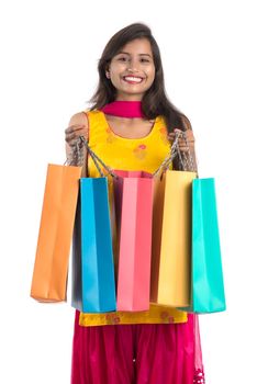 Beautiful Indian young girl holding and posing with shopping bags on a white background