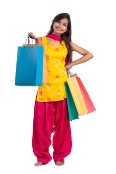 Beautiful Indian young girl holding and posing with shopping bags on a white background